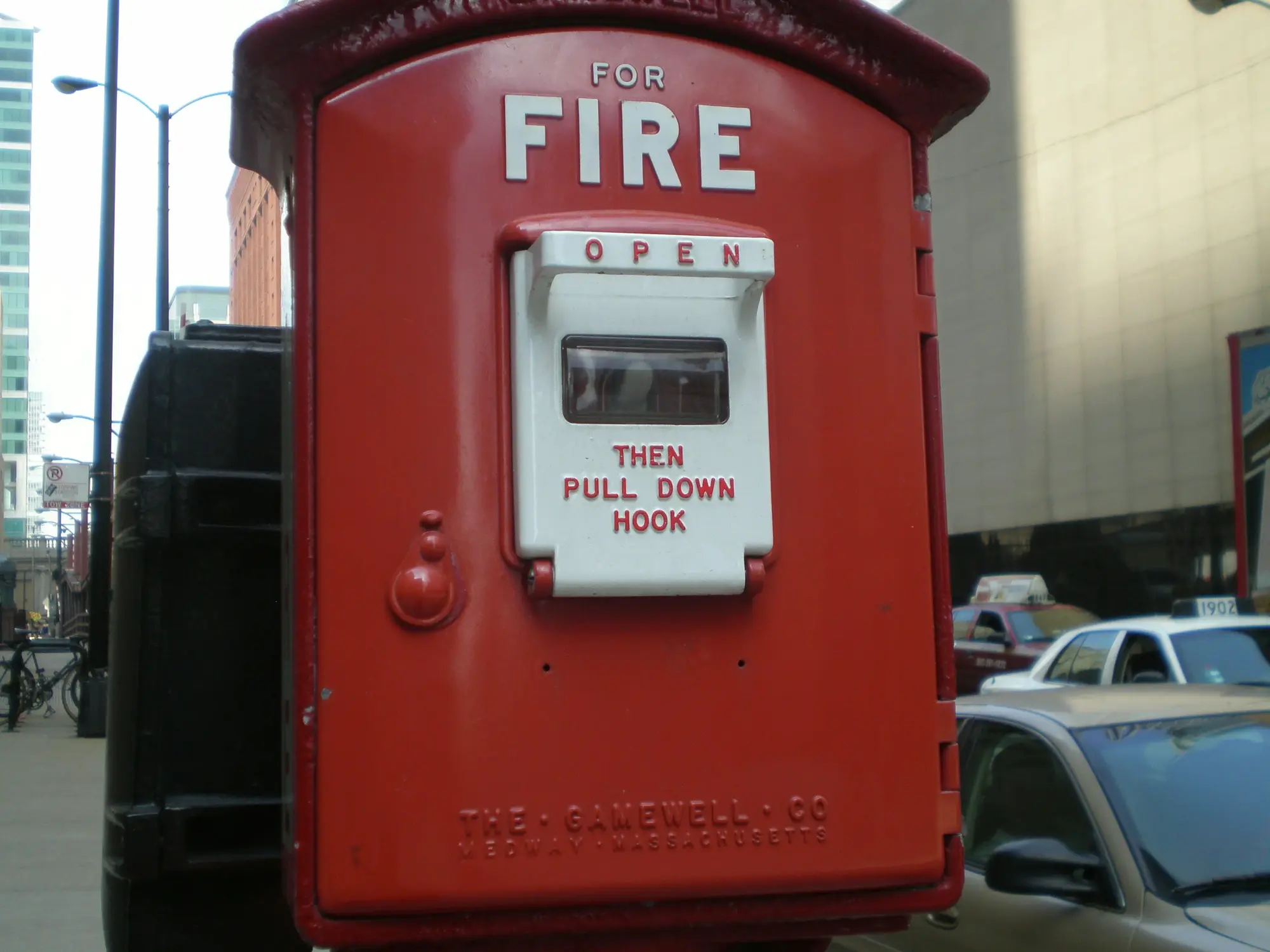 Antique red fire alarm box on a city sidewalk
