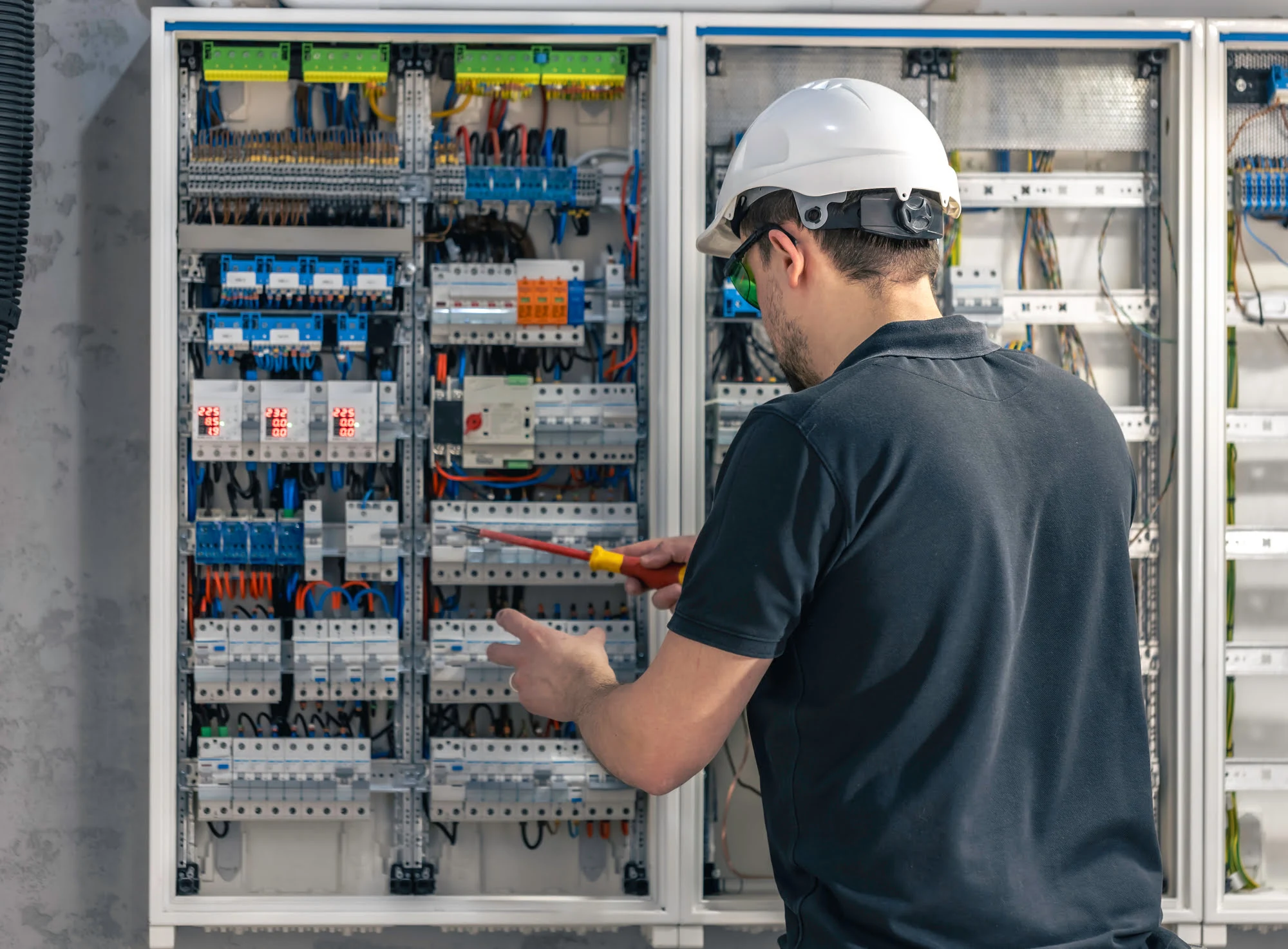 male-electrician-works-switchboard-using-electrical-connection-cable