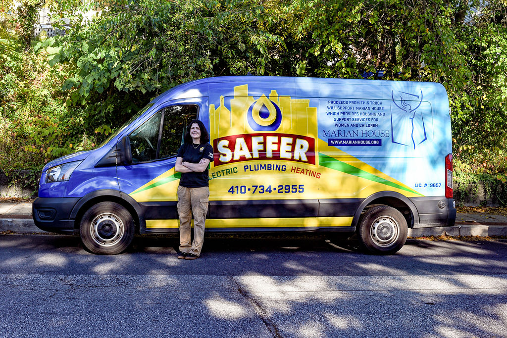 Lady electrician in baltimore in front of her work truck