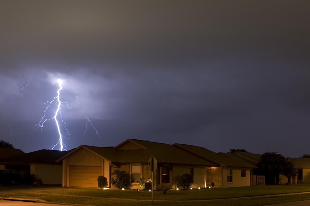a lightning strike at night above a home, could be the cause of a power surge